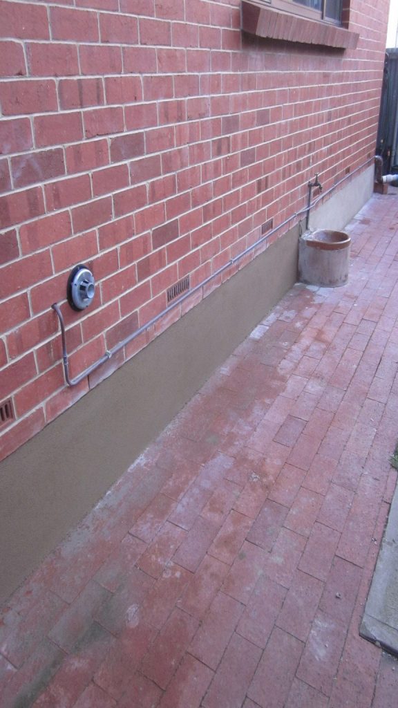 Concrete repairs side wall of house, after